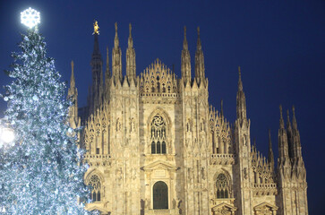 Gothic facade of the Milan Cathedral during the Christmas holidays with the huge Christmas tree...
