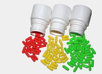 Tres botellas blancas volcadas, derramando cápsulas rojas, amarillas y verdes sobre una superficie...