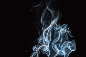 Smoke rises elegantly in dark background revealing intricate patterns and shapes