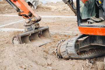 Fototapeta premium Broken excavator without track on building site awaiting repair