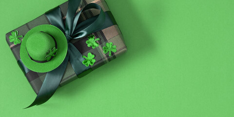 St. Patrick's Day greeting card on a green background with a gift box and a leprechaun hat. St....