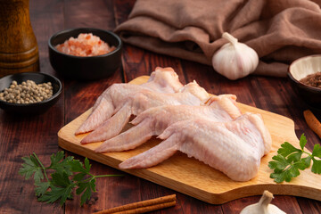 Fresh raw Chicken wings (Chicken 3 Joint Wing) on wooden plate.
