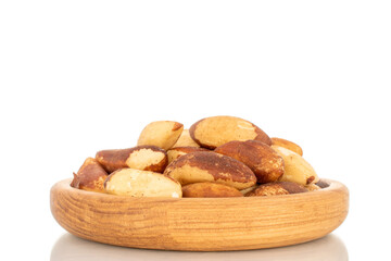 Brazil nuts without shells on a wooden plate, close-up, isolated on a white background.