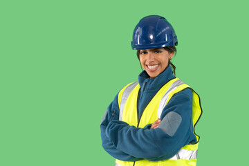 Smiling construction worker wearing safety gear poses with confidence against a green backdrop