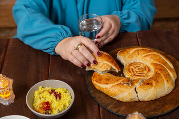Woman with hand eating flatbread iftar Ramadan at table
