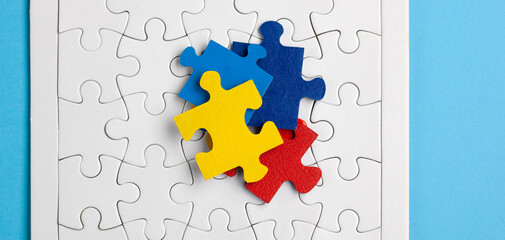 Autism Awareness Day, World Autism Day. Colorful and White Puzzles on Blue Background