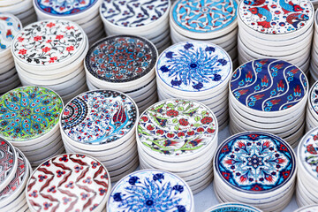 White ceramic coasters with oriental patterns are on a counter