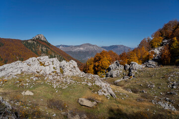 Autumn in the Prokletije Mountains (Montenegro). Hiking trail to Volusnica, rock formations, red, orange colours, grebaje valley area