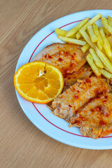 Roasted pork loin served with crispy fries on a traditional Portuguese restaurant table, showcasing authentic cuisine and warm dining ambiance.