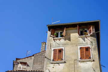 Traditional, typical historical apartment house in old town of Rovinj against a blue sky, Croatia