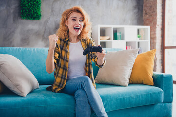 Obraz premium Photo of attractive young blonde woman sit couch winning video game dressed yellow plaid outfit cozy day light home interior living room
