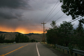 colorful sunset view out of window of RV Trailer, sunset in nature national forest, rainstorm