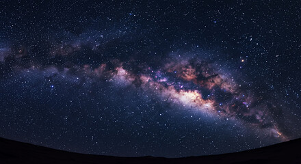 Obraz premium Majestic Milky Way Galaxy Arching Over Dark Landscape at Night