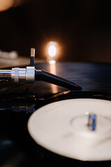 Close-up of a vinyl record player stylus with warm light ambiance, capturing analog music vibes