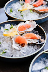 Fresh oysters on ice with grapefruit slices and lemon garnish for a gourmet dining experience