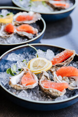 Fresh oysters on ice with grapefruit slices and lemon garnish for a gourmet dining experience