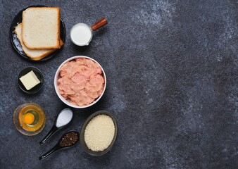 Prepared ingredients for cooking chicken cutlets on a black concrete background. Ingredient layout. Step-by-step recipes.