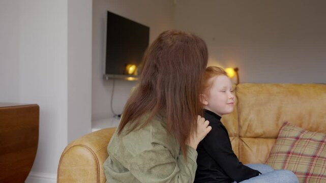 Child hairstyling tutorial featuring a mother preparing her daughter's hair at home