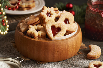 A bowl of homemade Linzer Christmas cookies filled with strawberry marmalade