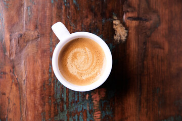 Cup of coffee on wooden background. Soft focus. Top view. Copy space