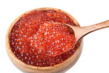 Close-up of wooden spoon with red caviar over broken bowl with caviar.