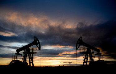 Oil drilling derricks at desert oilfield. Crude oil production from the ground. Oilfield services...