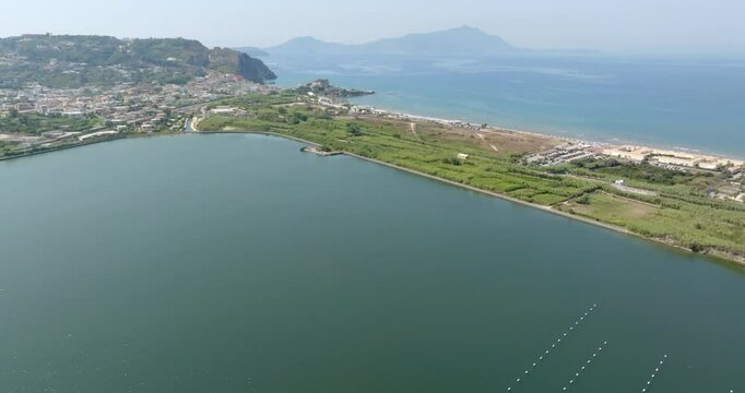 Aerial view of Fusaro Lake located in Bacoli, in the metropolitan city of Naples, Campania, Italy. It is separated from the sea by a narrow coastal strip. It was known by the Latins as Acherusia Palus