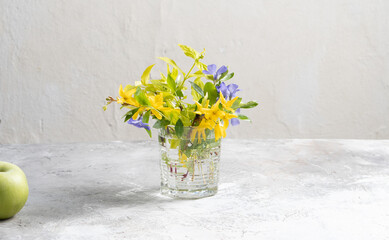 Bouquet of spring flowers in a vase on a light gray background