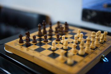Chess match in progress with wooden pieces on a checkered board