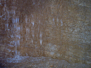 Eiszapfen an einer gefrorenen Felswand in einem Steinbruch