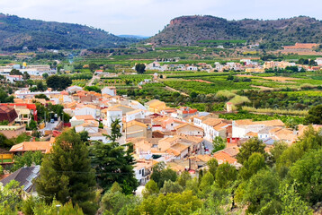 Naklejka premium Torres Torres town village, Valencia, Spain. Rural landscape. Buildings and houses in city. Town at mountain. Town at Mountains hills. Houses roofs in countryside. Olive farm field, Orange field