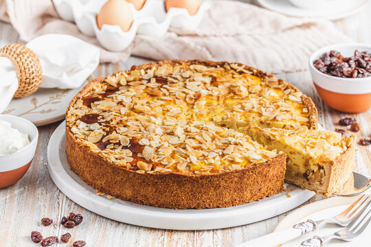 Homemade apple pie with roasted almonds on white wooden background
