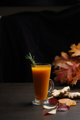 Sea buckthorn tea in a tall transparent mug on a black background