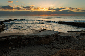 Obraz premium Paisaje marítimo de amanecer sobre el antiguo embarcadero del saladar en la playa de Agua Amarga, Alicante, España
