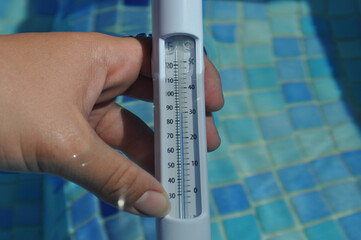 Water thermometer in swimming pool with water temperature of 30 degrees