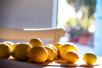 Natural lemons on the table illuminated by the light coming through the door