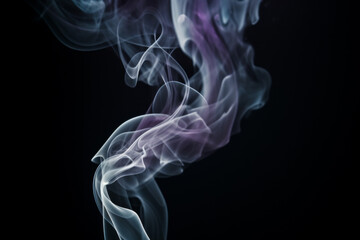 Fototapeta premium Swirling smoke patterns create mesmerizing shapes against a dark background
