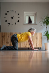 Senior man stretching his back in a gentle yoga or pilates practice