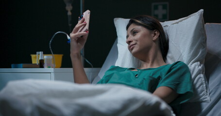 Hospitalized young woman with oxygen tube in her nose, engaged in a video chat.