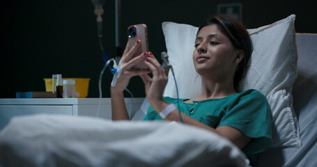 Hospitalized young woman with oxygen tube in her nose, engaged in a video chat.