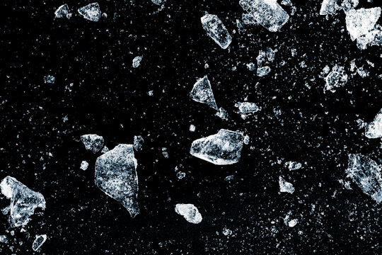 Ice, crushed on a black background. Shards of crushed ice spread away. The explosion of ice.