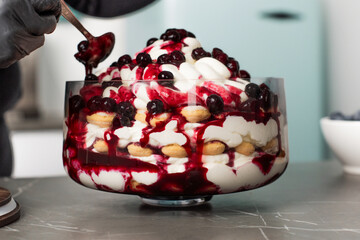 Delicious layered dessert showcases fresh berries and whipped cream at a home kitchen