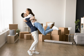 In spacious unfurnished living room couple celebrate relocation day to their new first own house,...