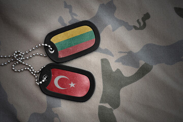 vintage army blank, dog tag with flag of lithuania and turkey on the khaki texture background....