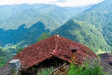 Obraz premium rustic red-tiled roof amidst the lush green valleys of Turkey, highlighting the scenic beauty and rural charm of the region.