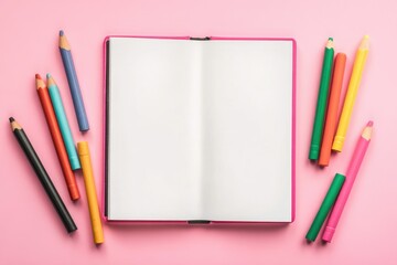 Colorful wax crayons on white sketchbook with pink background.