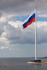 Fototapeta premium Flag of Russian Federation is flying in air on blue sky and white cumulus clouds. National flag of Russian. vertical photo.