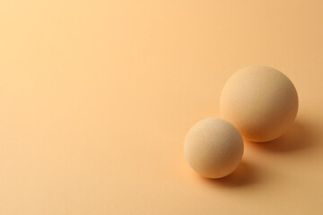Two textured balls on beige background, space for text