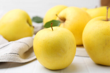 Fresh ripe yellow apples on white tiled table, closeup