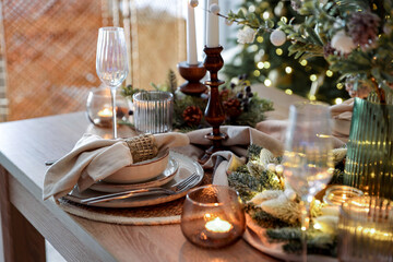 Christmas place setting with festive decor on wooden table in room